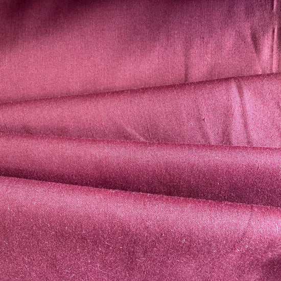 Smooth solid broadcloth fabric with a crisp hand feel and durable structure.