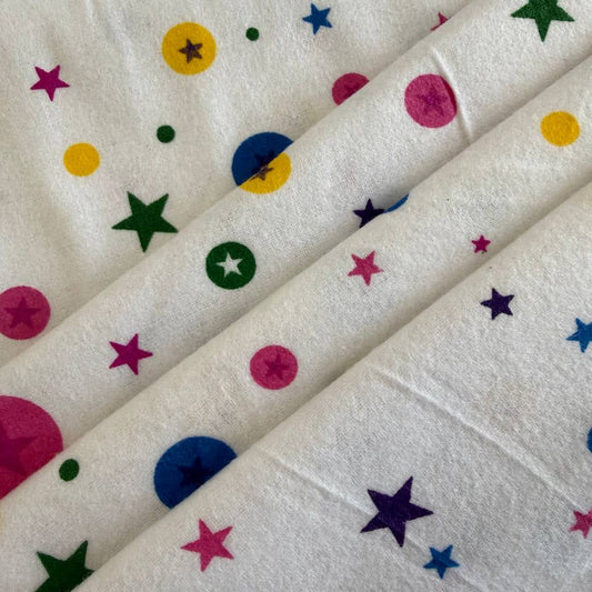 Printed flannelette fabric with pink and yellow pattern folded on bolt 