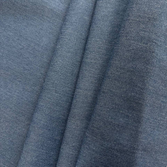 Denim blue stretch denim fabric folded showing smooth woven texture