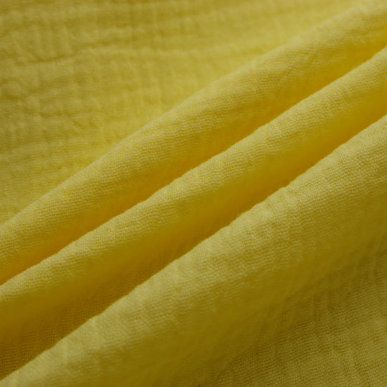 This soft double gauze cotton fabric has a light airy texture with a gently crinkled surface.