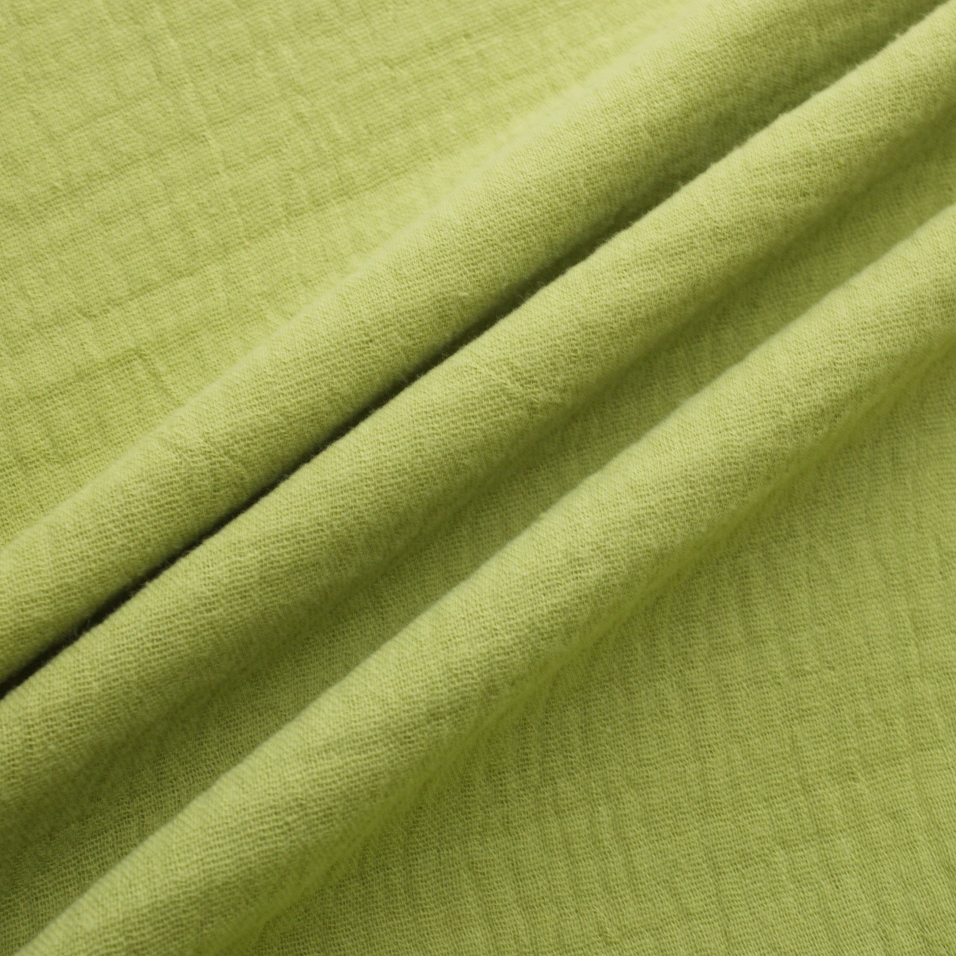 Sage green double gauze cotton fabric with soft crinkled texture