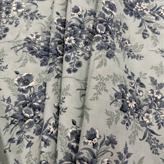 Breathtaking Blues Sky cotton fabric by 3 Sisters for Moda Fabrics featuring vintage blue and cream floral bouquets on a soft sky blue background.