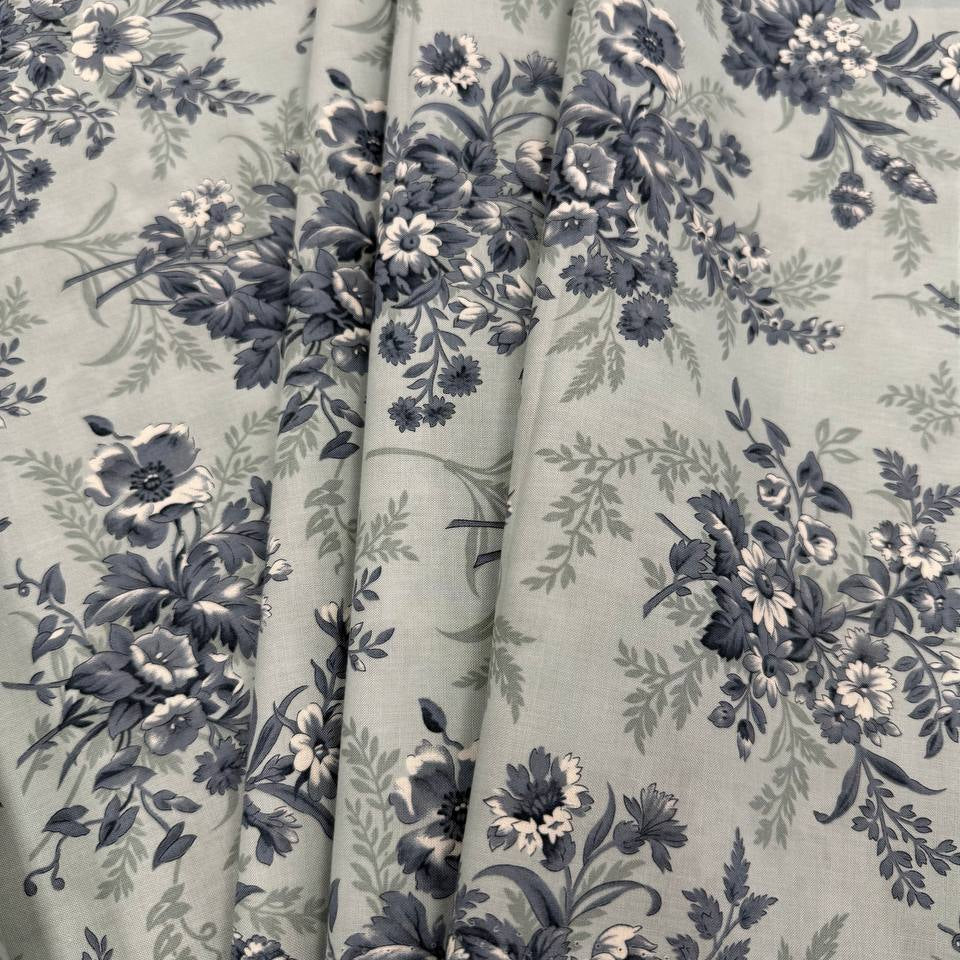Breathtaking Blues Sky cotton fabric by 3 Sisters for Moda Fabrics featuring vintage blue and cream floral bouquets on a soft sky blue background.