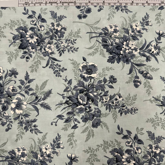 Breathtaking Blues Sky cotton fabric by 3 Sisters for Moda Fabrics featuring vintage blue and cream floral bouquets on a soft sky blue background.