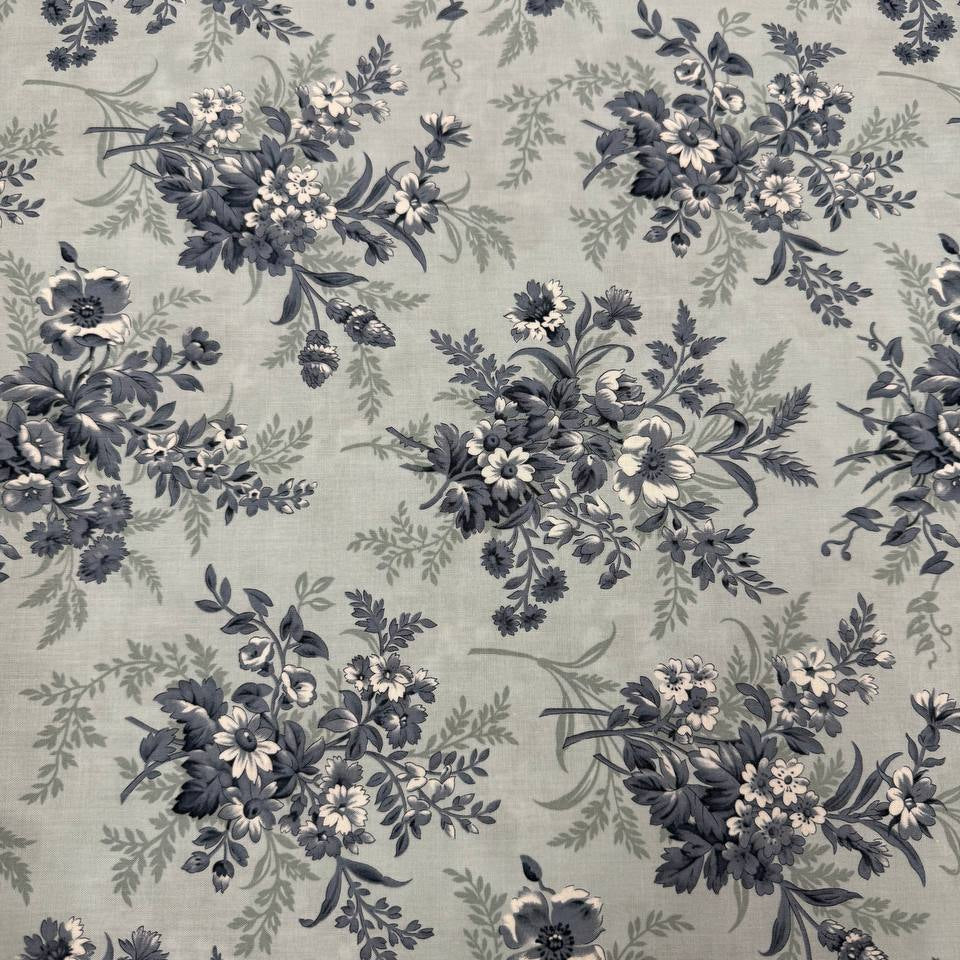 Breathtaking Blues Sky cotton fabric by 3 Sisters for Moda Fabrics featuring vintage blue and cream floral bouquets on a soft sky blue background.
