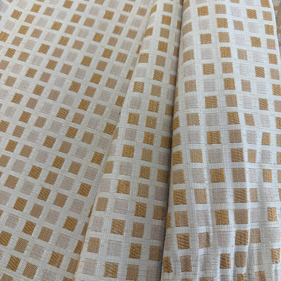 Cream and gold upholstery fabric with a small woven geometric square pattern, suitable for decorative pillows, cushions, furniture upholstery, and home décor.