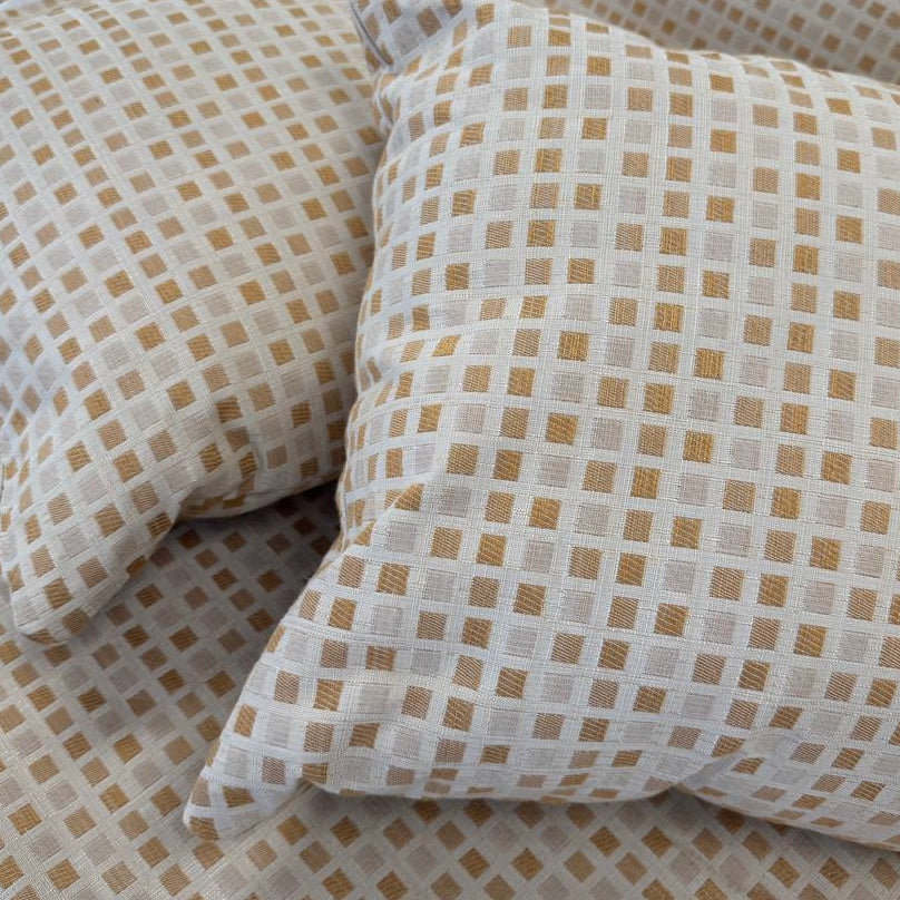 Cream and gold upholstery fabric with a small woven geometric square pattern, suitable for decorative pillows, cushions, furniture upholstery, and home décor.