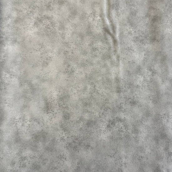 Stack of Northcott Shimmer Basics speckled quilting cotton fabrics in pastel shades with subtle metallic shimmer.