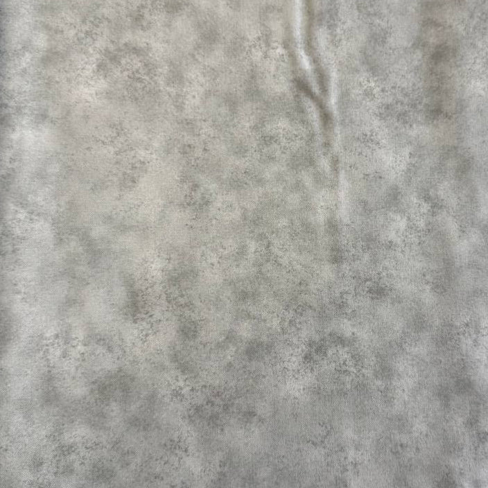 Stack of Northcott Shimmer Basics speckled quilting cotton fabrics in pastel shades with subtle metallic shimmer.
