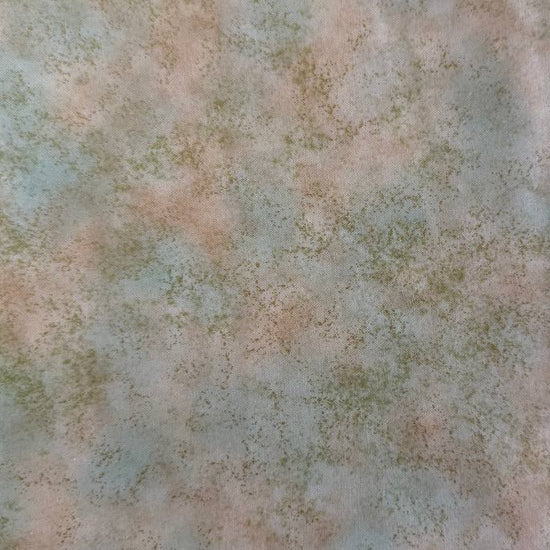 Stack of Northcott Shimmer Basics speckled quilting cotton fabrics in pastel shades with subtle metallic shimmer.