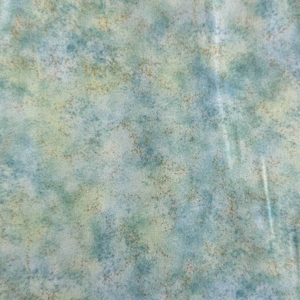 Stack of Northcott Shimmer Basics speckled quilting cotton fabrics in pastel shades with subtle metallic shimmer.