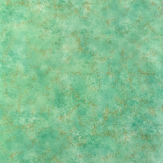 Stack of Northcott Shimmer Basics speckled quilting cotton fabrics in pastel shades with subtle metallic shimmer.