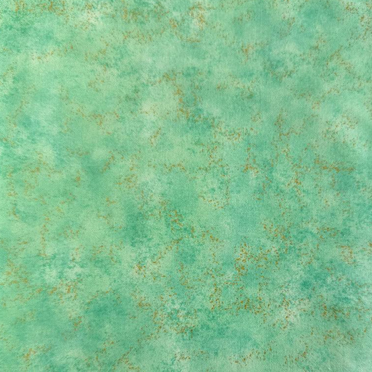 Stack of Northcott Shimmer Basics speckled quilting cotton fabrics in pastel shades with subtle metallic shimmer.