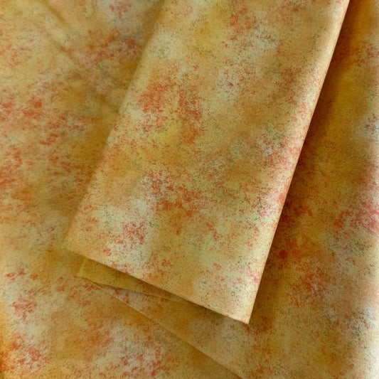 Stack of Northcott Shimmer Basics speckled quilting cotton fabrics in pastel shades with subtle metallic shimmer.