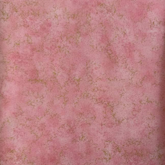 Stack of Northcott Shimmer Basics speckled quilting cotton fabrics in pastel shades with subtle metallic shimmer.