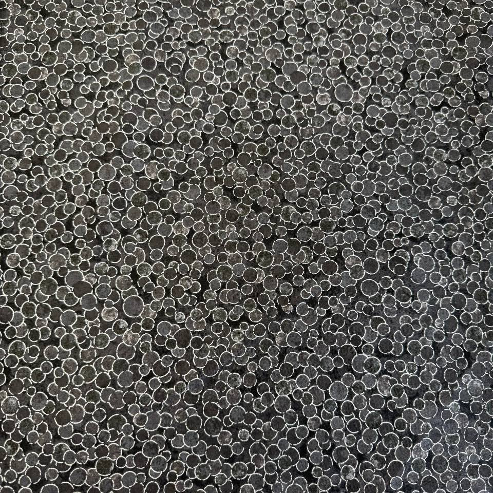 Fabric featuring an abstract all-over pattern of layered circular bubble motifs in varying sizes with a textured artistic design.