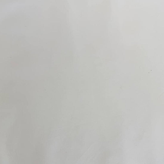 Extra wide 100% cotton premium muslin fabric folded on bolt in fabric shop.