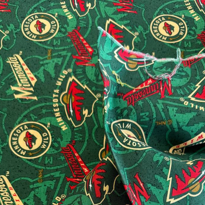 Licensed Minnesota Wild NHL cotton fabric with repeating team logos and hockey-themed print on cotton fabric.