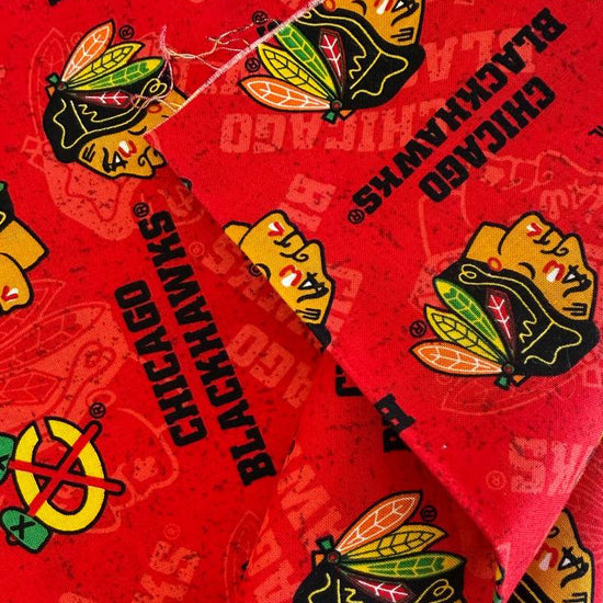 Licensed Chicago Blackhawks NHL cotton fabric featuring repeating team logos and hockey-themed print on cotton fabric.