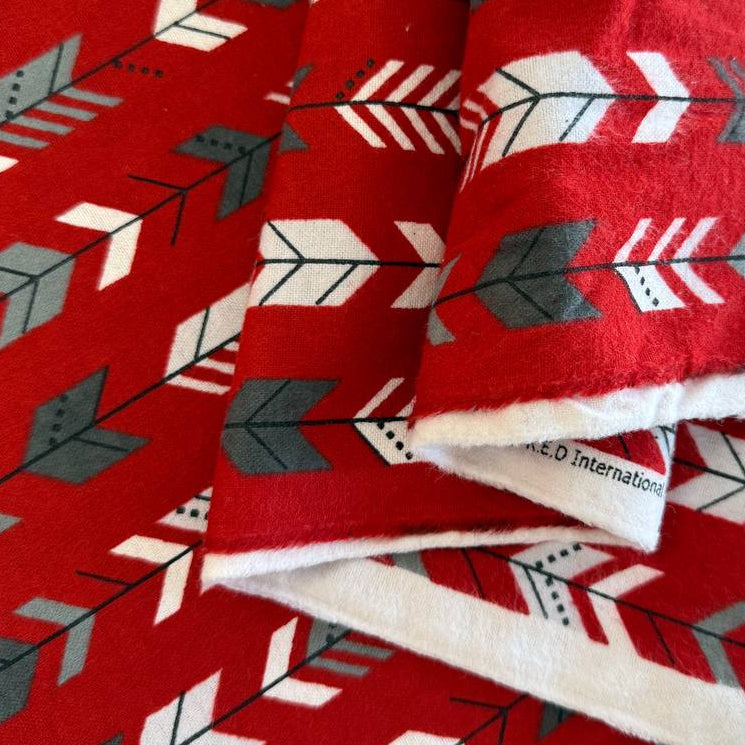 Red cotton flannelette fabric with white and gray arrow print pattern.