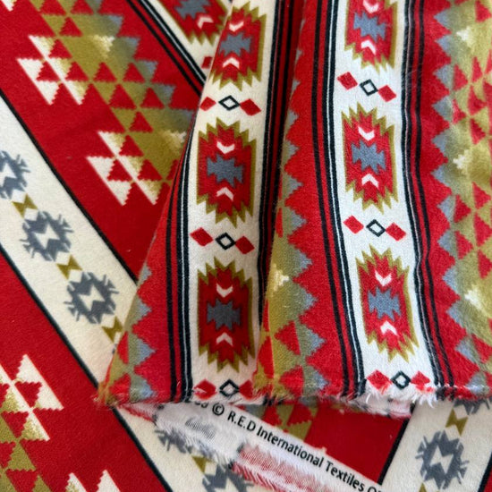 Red cotton flannelette fabric with southwestern stripe pattern in cream, gray, olive, and black tones.