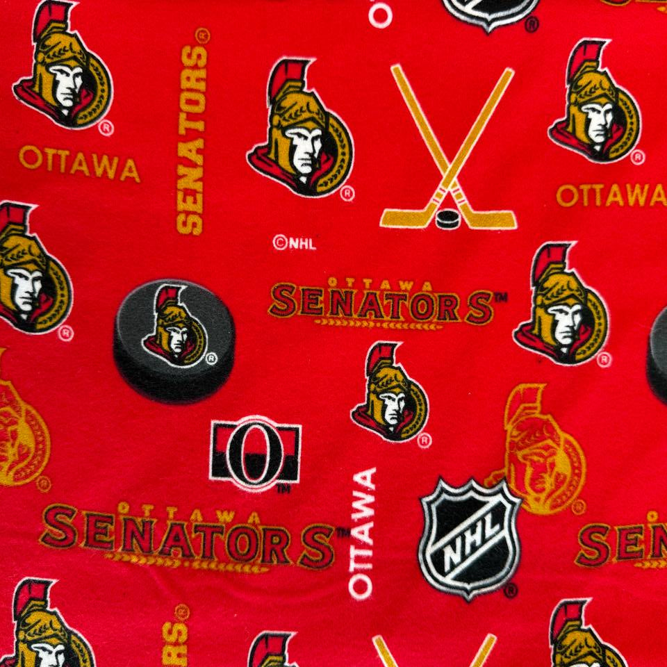 Ottawa Senators NHL cotton flannel fabric with hockey logos, pucks, and sticks on a bright background.