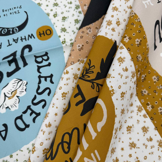 Wellspring inspirational Christian cotton fabric panel by Fancy That Design House for Moda, featuring faith quotes and floral designs in blue, cream, tan and mustard.