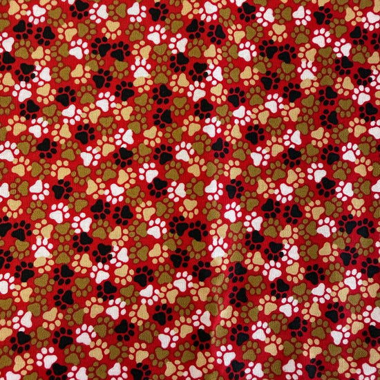 All-over paw print cotton fabric with a scattered animal footprint pattern.
