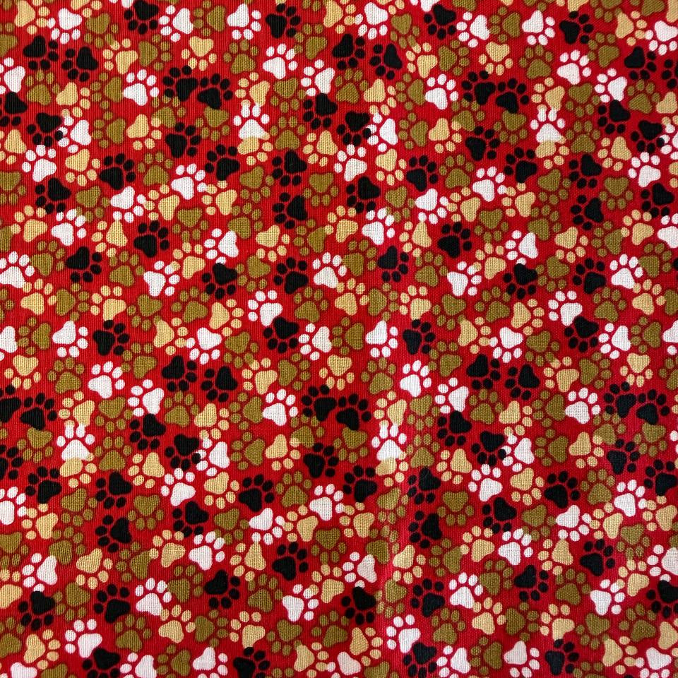 All-over paw print cotton fabric with a scattered animal footprint pattern.
