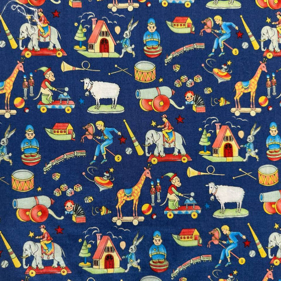 Navy blue cotton fabric featuring vintage toy illustrations including elephants, giraffes, trains, drums, rocking horses, and toy houses.