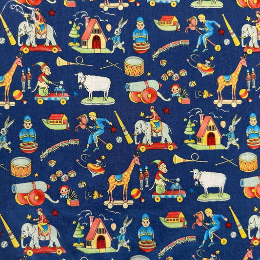 Navy blue cotton fabric featuring vintage toy illustrations including elephants, giraffes, trains, drums, rocking horses, and toy houses.