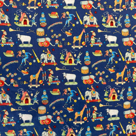 Navy blue cotton fabric featuring vintage toy illustrations including elephants, giraffes, trains, drums, rocking horses, and toy houses.