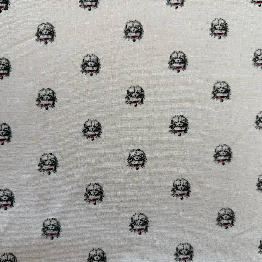 Cream cotton fabric with small repeating black and red toile-style motifs by Marcus Fabrics.
