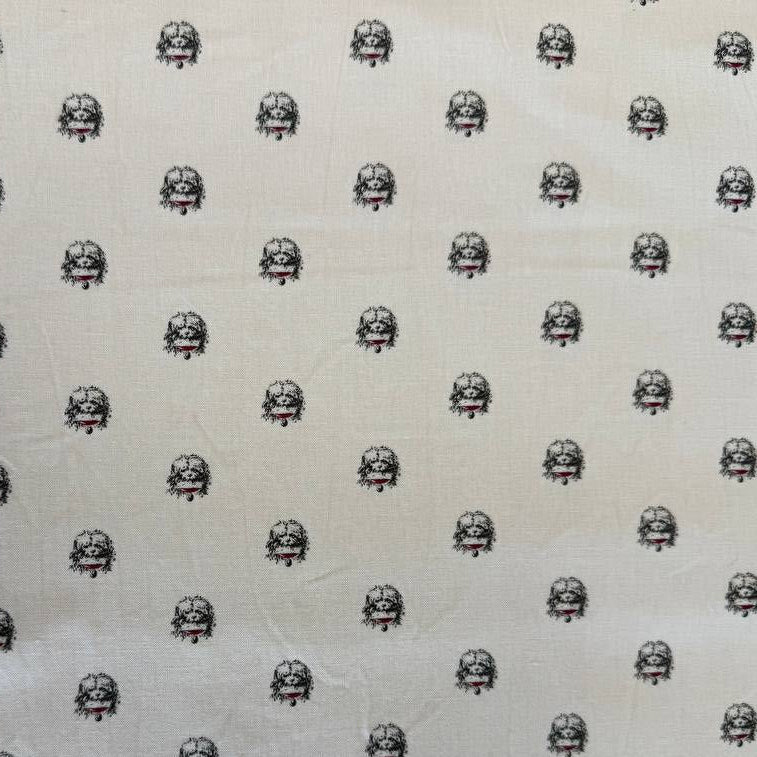 Cream cotton fabric with small repeating black and red toile-style motifs by Marcus Fabrics.