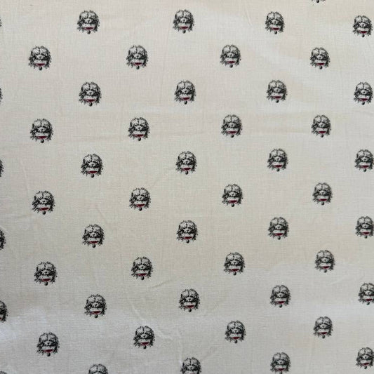 Cream cotton fabric with small repeating black and red toile-style motifs by Marcus Fabrics.