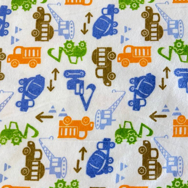 White flannelette fabric featuring colorful construction vehicles including dump trucks, excavators, cranes, and cement mixers in blue, orange, green, and brown.