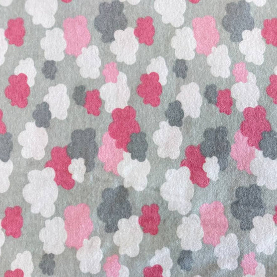 Soft flannelette fabric featuring pink, grey, and white cloud shapes on a light grey background in a playful nursery-inspired pattern.