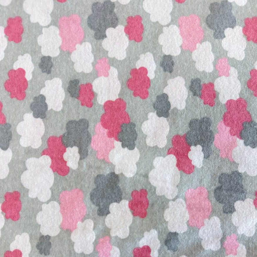 Soft flannelette fabric featuring pink, grey, and white cloud shapes on a light grey background in a playful nursery-inspired pattern.