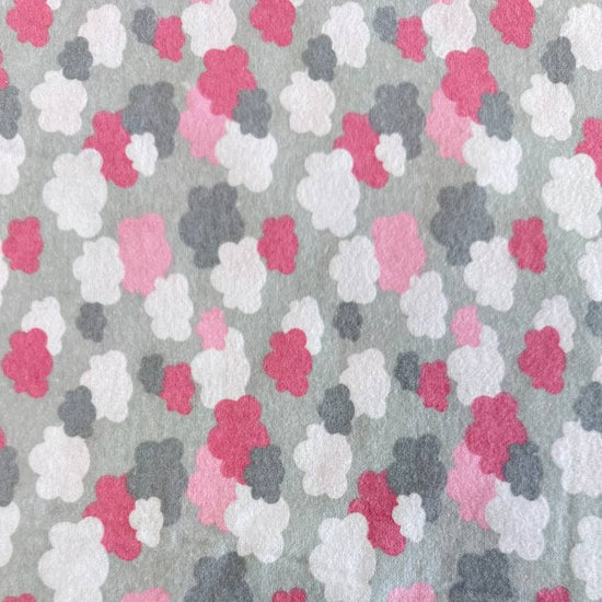 Soft flannelette fabric featuring pink, grey, and white cloud shapes on a light grey background in a playful nursery-inspired pattern.