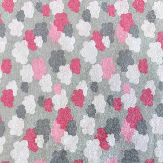 Soft flannelette fabric featuring pink, grey, and white cloud shapes on a light grey background in a playful nursery-inspired pattern.