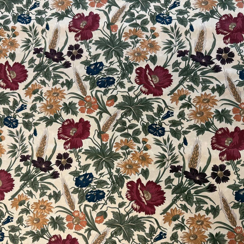 Wheatland floral quilting cotton fabric by Kansas Troubles Quilters for Moda Fabrics featuring vintage flowers, foliage, and wheat motifs in Wheat and Slate colorways.