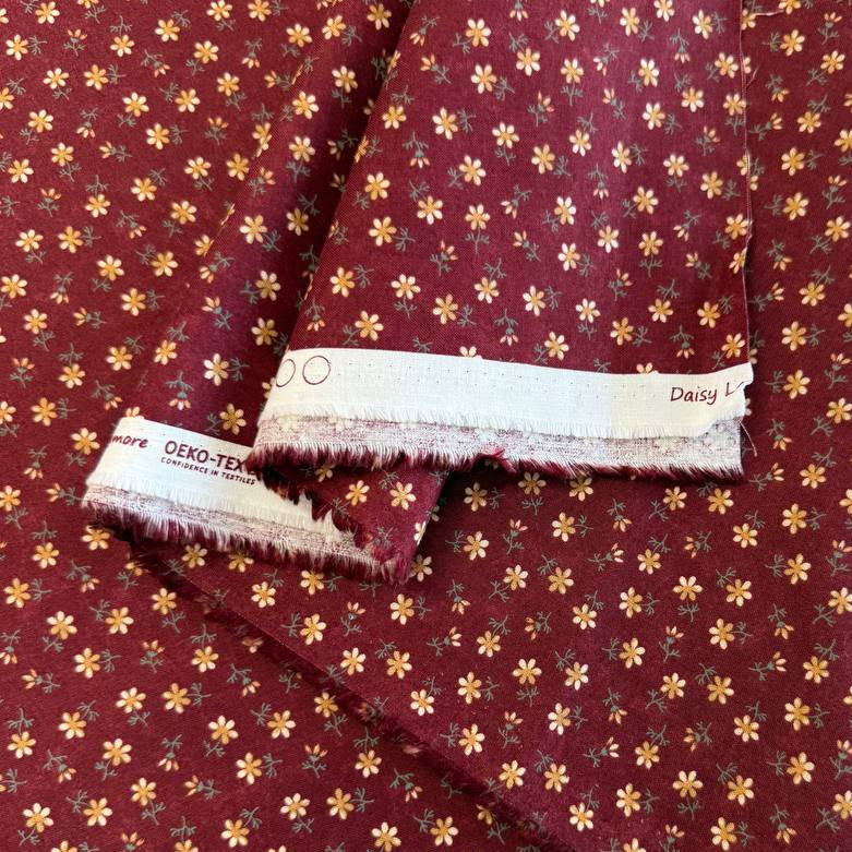 Small floral quilting cotton fabric from the Daisy Lane collection by Kansas Troubles Quilters for Moda Fabrics featuring scattered blossoms in Carnation and Mulch colorways.