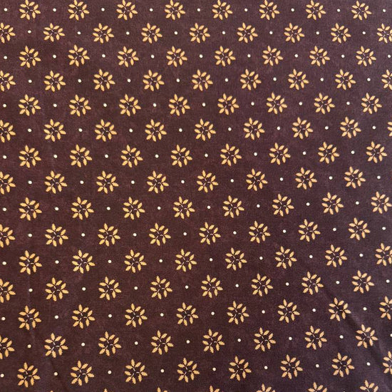 Wheatland quilting cotton fabric by Kansas Troubles Quilters for Moda Fabrics featuring a small repeating floral motif in warm beige tones on a rich mulberry background.