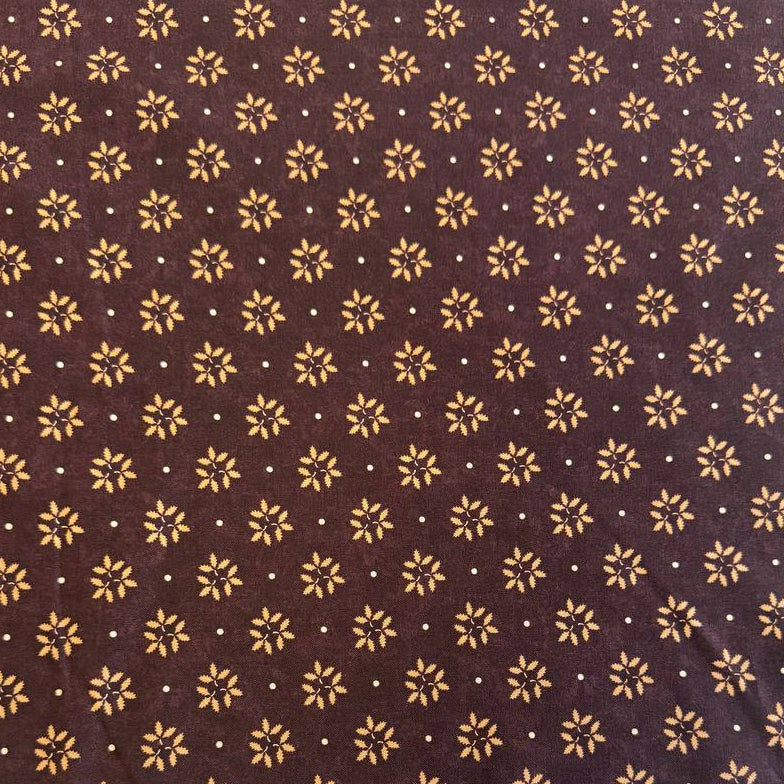 Wheatland quilting cotton fabric by Kansas Troubles Quilters for Moda Fabrics featuring a small repeating floral motif in warm beige tones on a rich mulberry background.