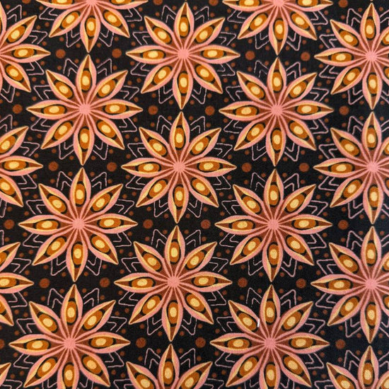 Acorn Hollow quilting cotton fabric by BasicGrey for Moda Fabrics featuring repeating geometric starburst motifs in pink, gold, and amber tones on a deep soil brown background.