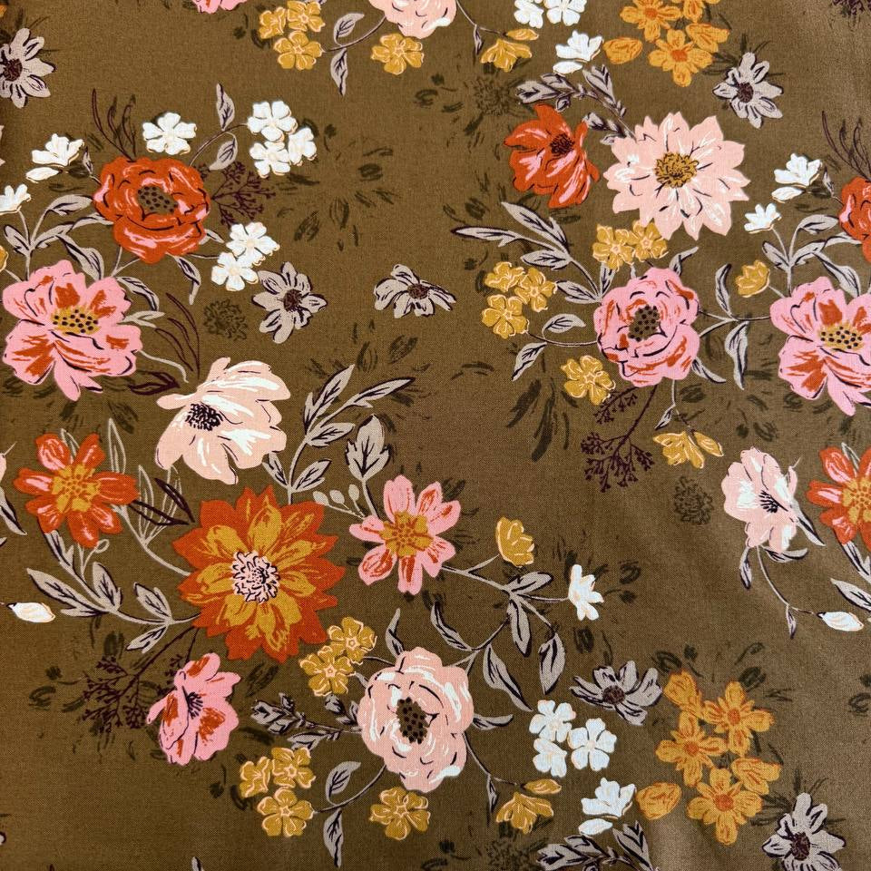 Floral quilting cotton fabric from the Foraged, Found and Hand Me Down collection by Fancy That Design House for Moda Fabrics featuring wildflowers and botanical elements in pink, cream, yellow, and orange tones on an olive green background.