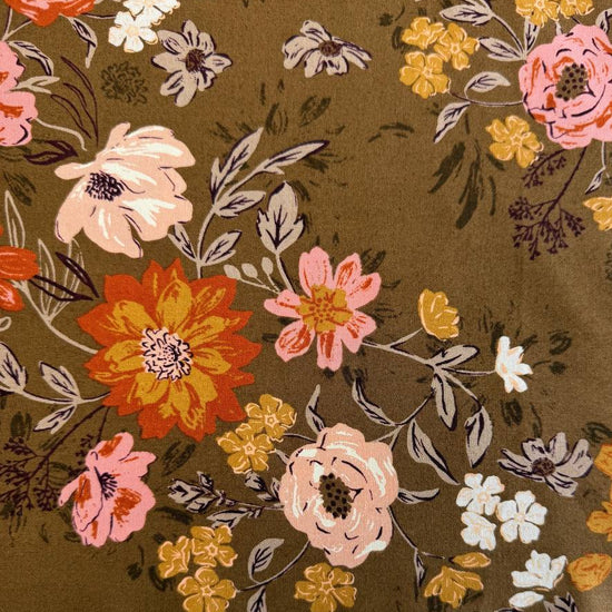 Floral quilting cotton fabric from the Foraged, Found and Hand Me Down collection by Fancy That Design House for Moda Fabrics featuring wildflowers and botanical elements in pink, cream, yellow, and orange tones on an olive green background.