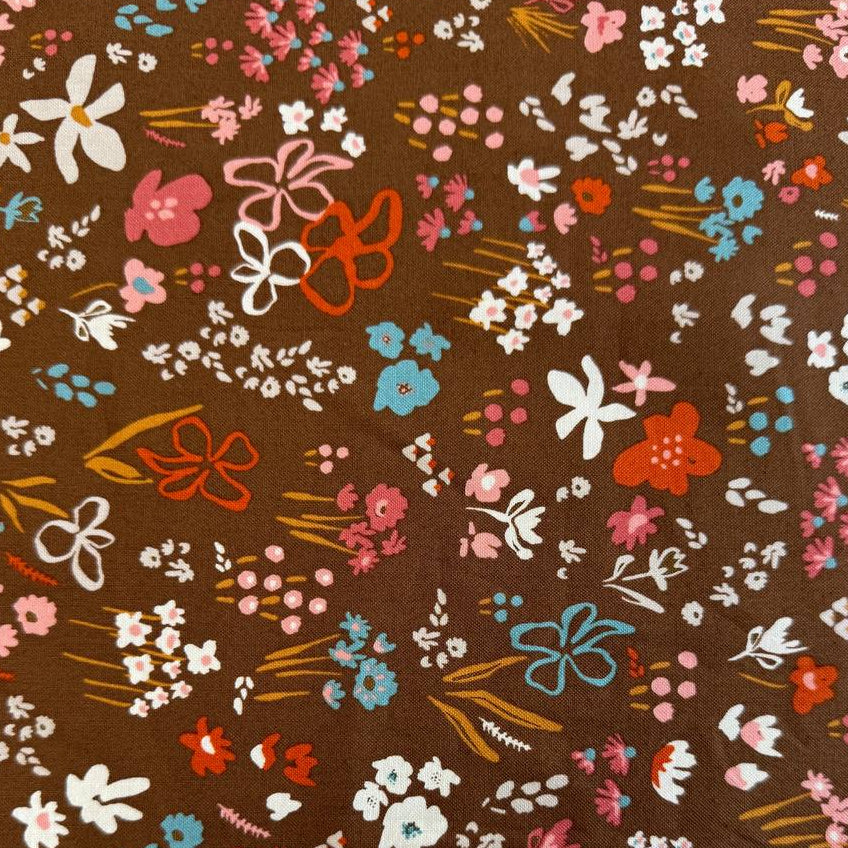 Small scattered wildflowers and botanical motifs on quilting cotton fabric, available in Deep Sea teal and Cocoa brown colourways from Moda's Things Above collection.