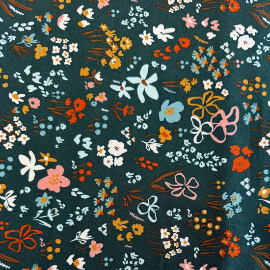 Small scattered wildflowers and botanical motifs on quilting cotton fabric, available in Deep Sea teal and Cocoa brown colourways from Moda's Things Above collection.