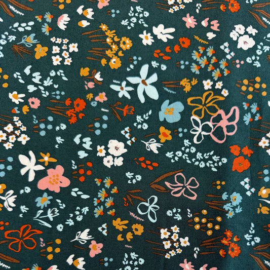 Small scattered wildflowers and botanical motifs on quilting cotton fabric, available in Deep Sea teal and Cocoa brown colourways from Moda's Things Above collection.
